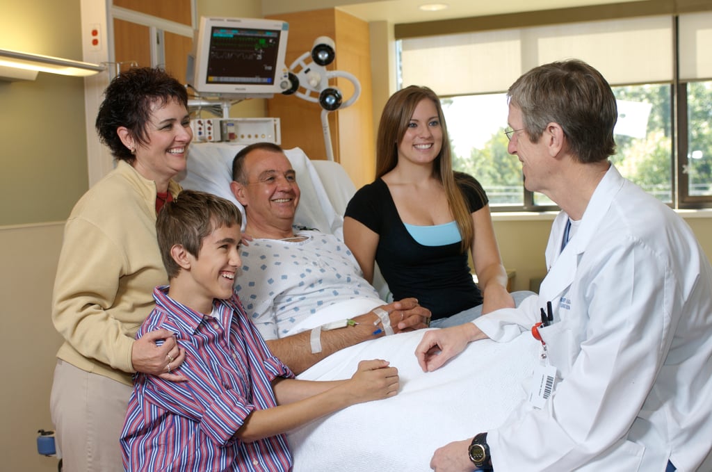 Hospital patient with caring family and doctor